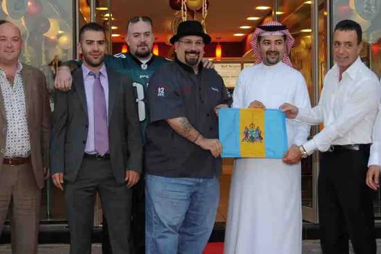 A long way from South Philly, Tony Luke Jr. (center) was surrounded by dignitaries at the grand opening of his sandwich shop in East Riffa,in the Middle Eastern Kingdom of Bahrain, last Sunday.