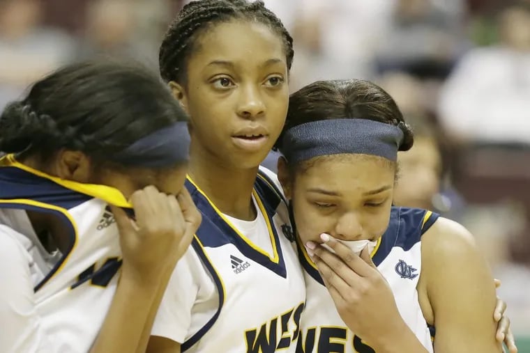 West Catholic’s Tamiah Robinson (left), Safara McIntyre (center) and Jaelyn Durrett (25) comfort each other after a 45-42 loss to Bellwood-Antis in the PIAA Class 2A final.
