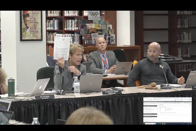 Perkiomen Valley Superintendent Barbara Russell holds up the district's policy prohibiting discrimination based on gender identity during a school board meeting Sept. 5. Seated next to her is board president Jason Saylor. The board on Monday banned transgender students from using bathrooms aligned with their gender identities.
