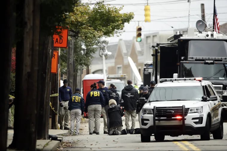 FBI gather near the Tree of Life Synagogue in Pittsburgh, Sunday, Oct. 28, 2018. Robert Bowers, the suspect in the mass shooting at the synagogue, expressed hatred of Jews during the rampage and told officers afterward that Jews were committing genocide and he wanted them all to die, according to charging documents made public Sunday.(AP Photo/Matt Rourke)