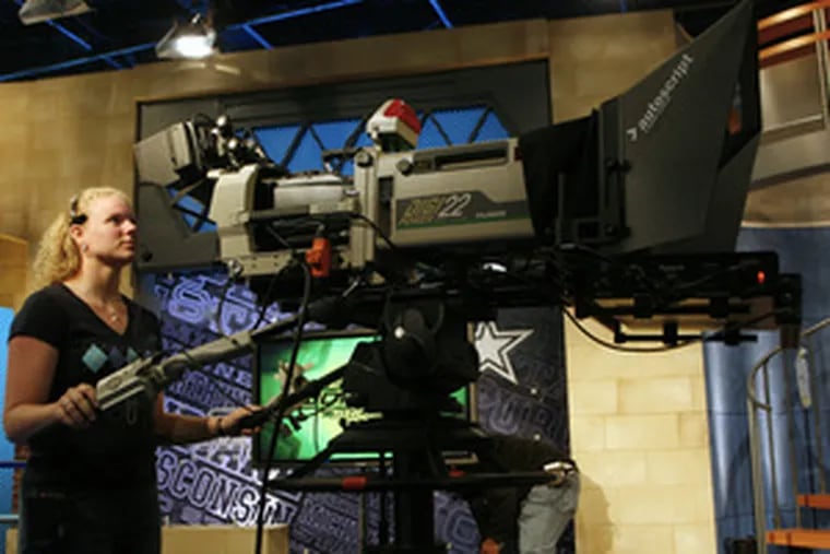 Big Ten Network technician Abigail Rakocy, above, adjusts a camera before the taping of the Big Ten Women&#0039;s Show in Chicago. At right, host Ann Kreiter puts on her microphone.