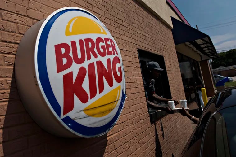 A Burger King Worldwide Inc. logo hangs outside a restaurant in Peoria, Ill.