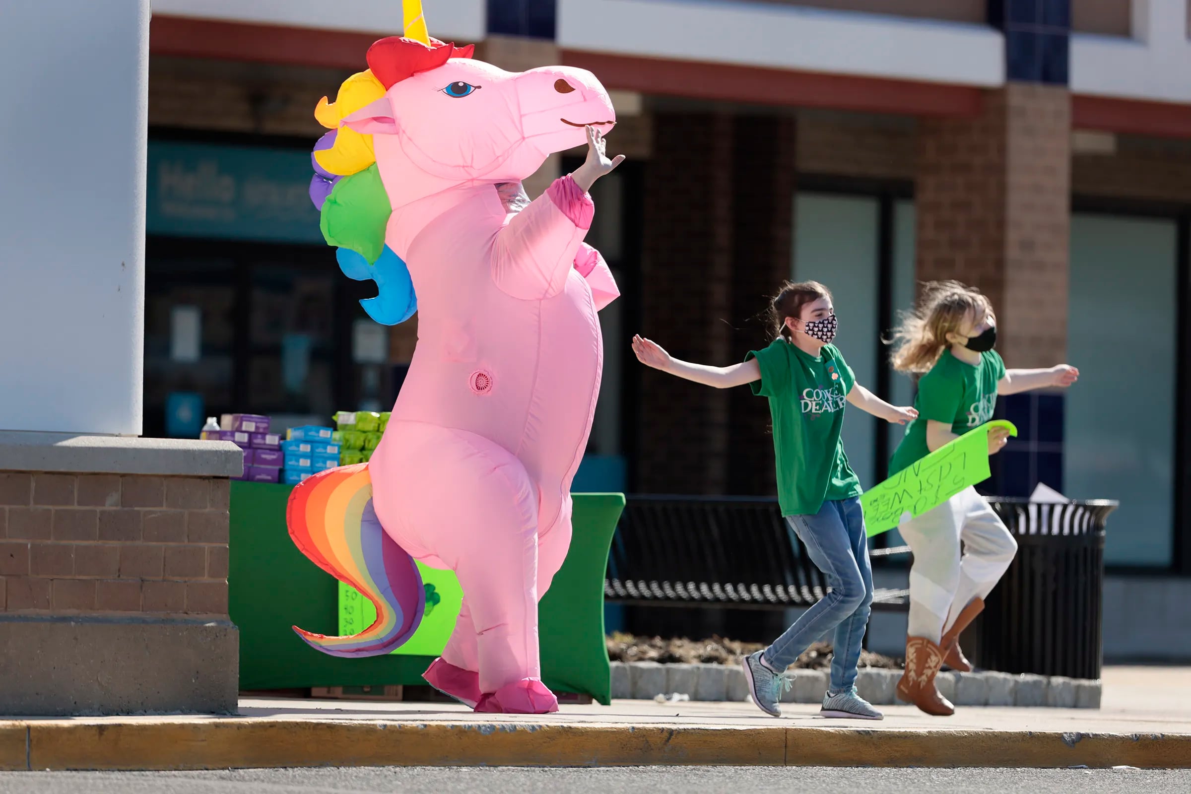 Shannon Pelosi put on an unicorn costume while her daughter Charlotte Pelosi, (middle) and Corinne McAdams danced to drum up more cookie sales at the Westmont Plaza shopping center in 2021.
