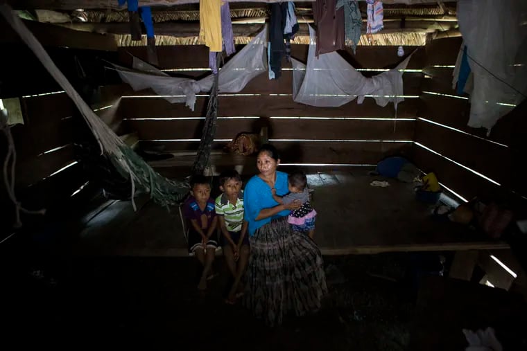 Claudia Maquin, 27, sits on a wooden bed while she answers questions from journalists with her three children, Elvis Radamel Aquiles Caal Maquin, 5, left, Abdel Johnatan Domingo Caal Maquin, 9, center, Angela Surely Mariela Caal Maquin, 6 months, right, in Raxruha, Guatemala, on Dec. 15. Claudia Maquin's daughter, 7-year old Jakelin Amei Rosmery Caal, died in a Texas hospital, two days after being taken into custody by border patrol agents in a remote stretch of New Mexico desert. (AP Photo/Oliver de Ros)