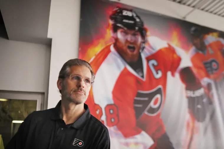 Flyers GM Ron Hextall is shown standing by a photo of star left winger Claude Giroux last year at the Skate Zone in Voorhees. Hextall will oversee the Flyers' portion of the draft Thursday and Friday.