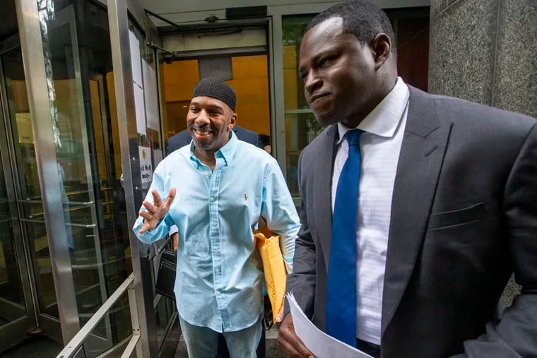 Eric Riddick, 51, (left) who was sentenced to life in prison after being convicted of first-degree murder for a 1991  shooting that killed a 20-year-old man in Southweat Philadelphia. He was released from the Stout Center for Criminal Justice in Philadelphia on Friday after a hearing. At right is his attorney, Emeka Igwe, the moment Riddick walked out of the courthouse.