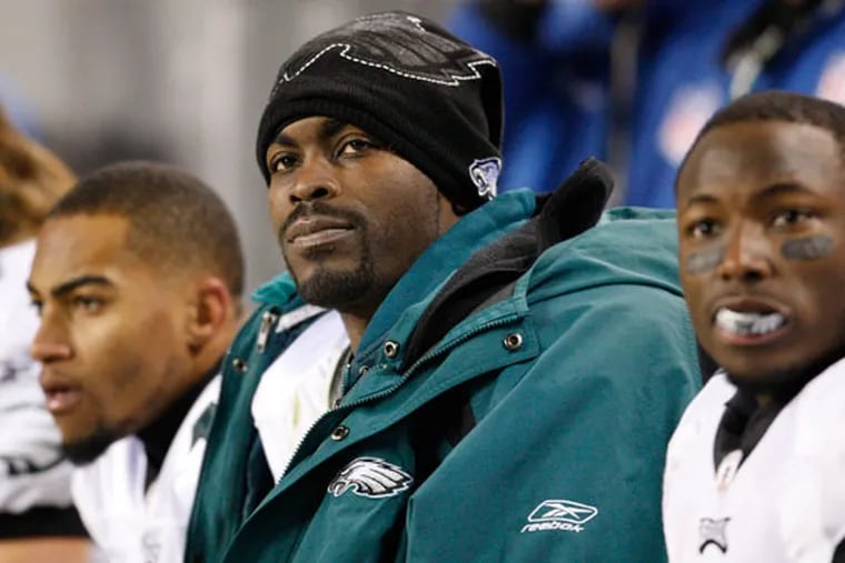 Eagles Michael Vick, flanked by DeSean Jackson, left, and LeSean McCoy, watches a game.