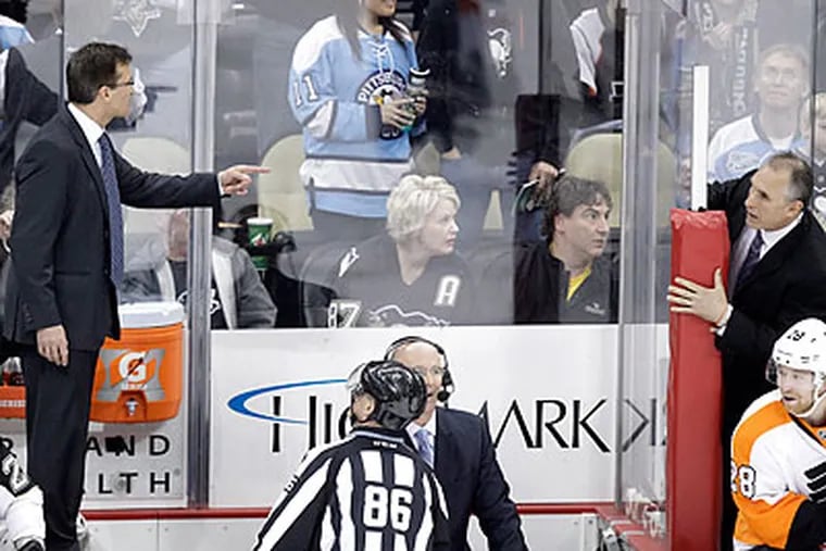 The Flyers' and Penguins' coaches got into a shouting match from their benches late in Sunday's game. (Gene J. Puskar/AP)