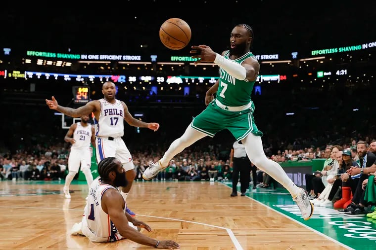 Sixers guard James Harden falls down as Boston Celtics guard Jaylen Brown passes the basketball during the second quarter of Game 7 of the NBA Eastern Conference semifinal playoff series in Boston, MA on Sunday, May 14, 2023. Brown recovered the ball. 