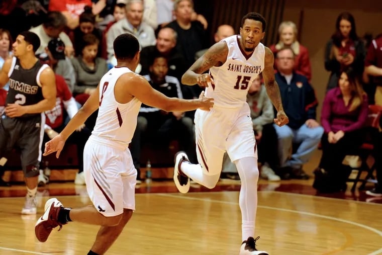 St. Joseph's Isaiah Miles (15) is congratulated by teammate Lamar Kimble after sinking a three-pointer in December.