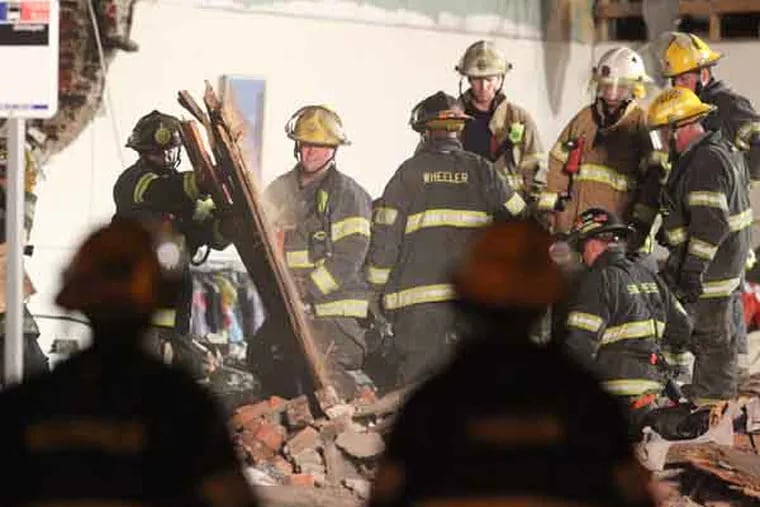 Fire fighters remove rubble from the collapsed building at 22nd and Market Sts.   ( CHARLES FOX / Staff Photographer )