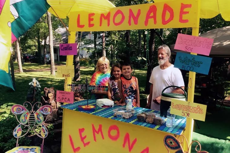 Diana and John Ochotny flank their grandkids Sophia and Andrew at a lemonade stand at the Philly Folk Festival. (Jonathan Takiff/Staff)