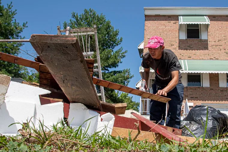 In this 2020 file photo, Binh Nguyen cleans up from flood damage at his Philadelphia home. Homeowners are increasingly concerned about extreme weathe. The home insurance agency Hippo shared some home maintenance tips for this time of year.