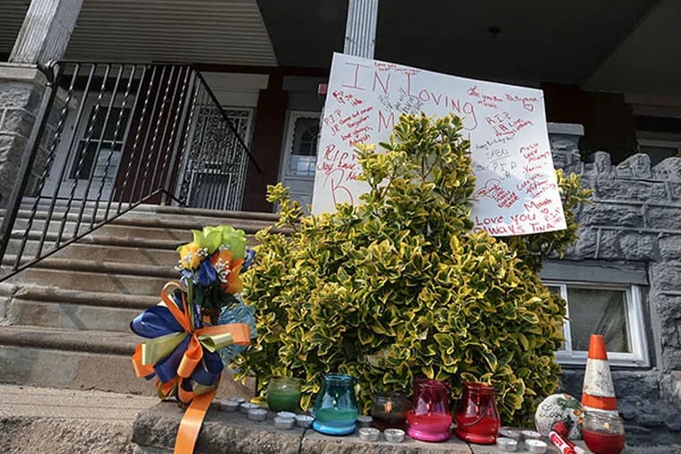 A memorial is set in front of the house on Christian Street where a man allegedly killed his brother. STEVEN M. FALK / STAFF PHOTOGRAPHER