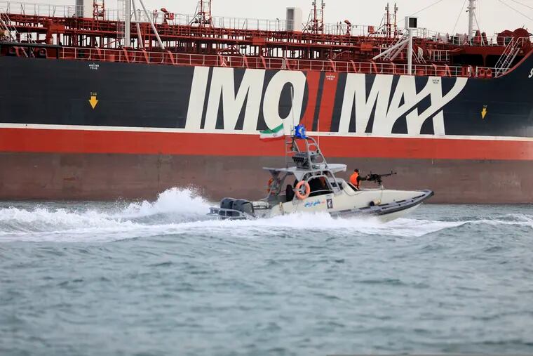In this Sunday, July 21, 2019 photo, a speedboat of the Iran's Revolutionary Guard moves around a British-flagged oil tanker Stena Impero which was seized in the Strait of Hormuz on Friday by the Guard, in the Iranian port of Bandar Abbas. Global stock markets were subdued Monday while the price of oil climbed as tensions in the Persian Gulf escalated after Iran's seizure of a British oil tanker on Friday. (Morteza Akhoondi/Mehr News Agency via AP)