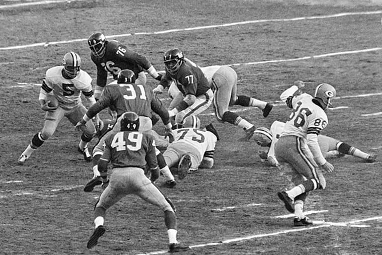 Green Bay halfback Paul Hornung (5) cuts off tackle to gain ten yards and a first down in first half of National Football League Championship game at Yankee Stadium in New York, on Dec. 30, 1962. Giant defenders are Roosevelt Grier (76), Dick Modzelewski (77), Bill Winter (31), Erich Barnes (49) and Allan Webb (21). Packers won, 16-7, for their second straight championship. (AP Photo)