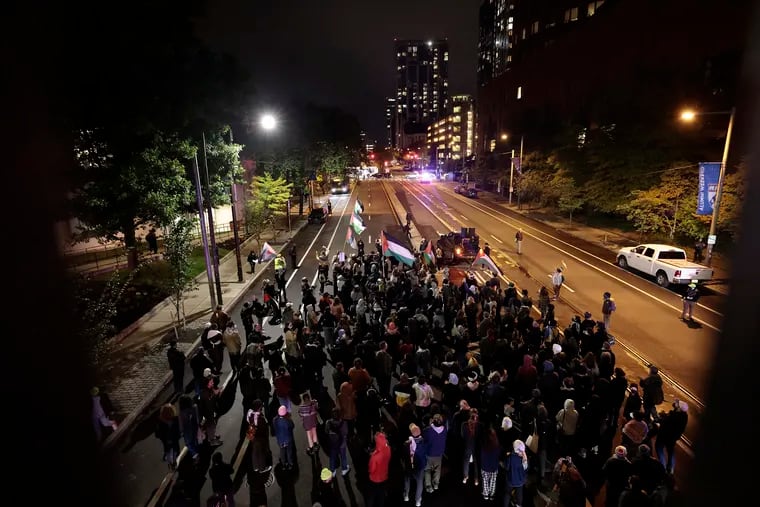 Pro-Palestinian activists march north on 38th St., towards Walnut St., in the University City section of Philadelphia on Friday.