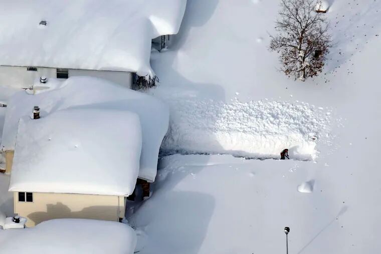 A man attempts to dig out his driveway in Depew, N.Y. More snow was on the way late Thursday.