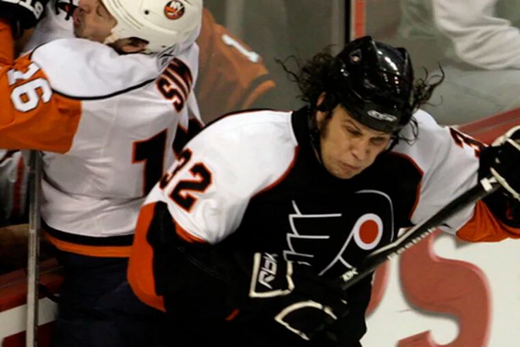 The Flyers&#0039; Riley Cote checks the Islanders&#0039; Jon Sim into the boards. Cote&#0039;s pass set up a goal.