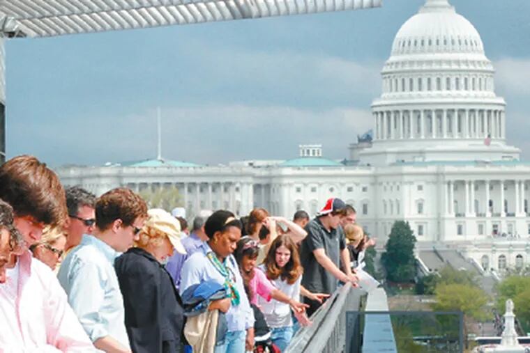 With the Capitol in the background, visitors gather on the terrace of the Newseum, the journalism museum recently moved from Virginia to Washington.