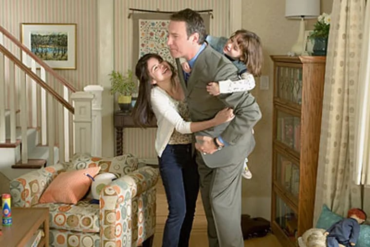 Sisters Beezus (left, Selena Gomez) and Ramona (Joey King) share an enthusiastic embrace with their father John Quimby (John Corbett).