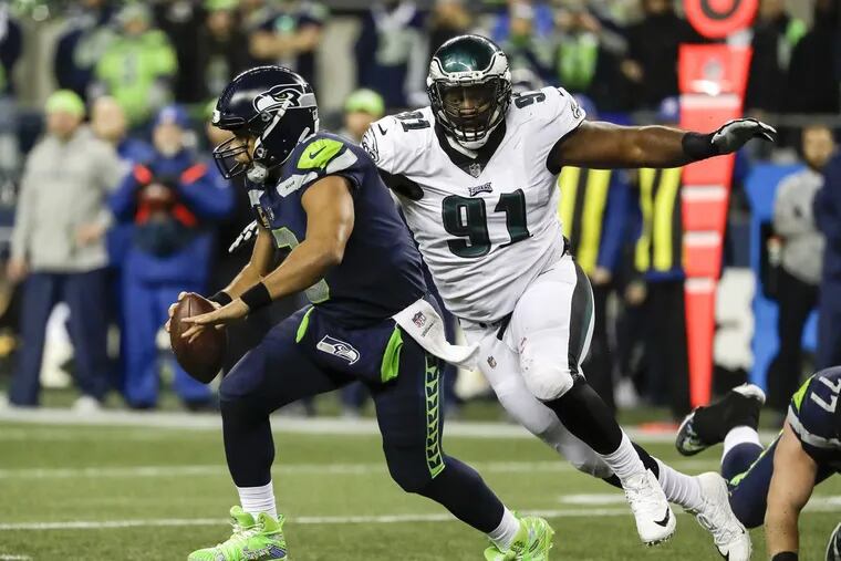 Seattle quarterback Russell Wilson runs past Eagles defensive tackle Fletcher Cox in the fourth quarter Sunday.
