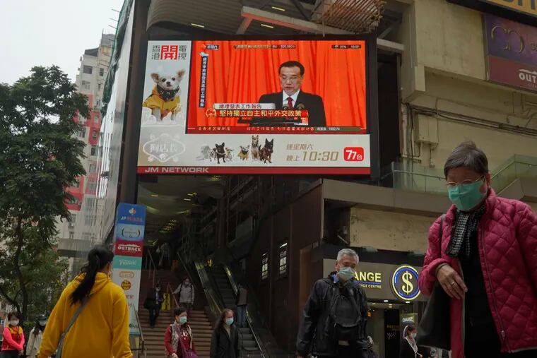 A TV screen broadcasts the news of the opening session of China's National People's Congress (NPC), in Hong Kong, Friday, March 5, 2021. A senior Chinese official says the largely pro-Beijing committee that currently elects the Hong Kong's leader will also elect some members of the city's legislature, as part of Beijing's planned revamp of Hong Kong's electoral system.