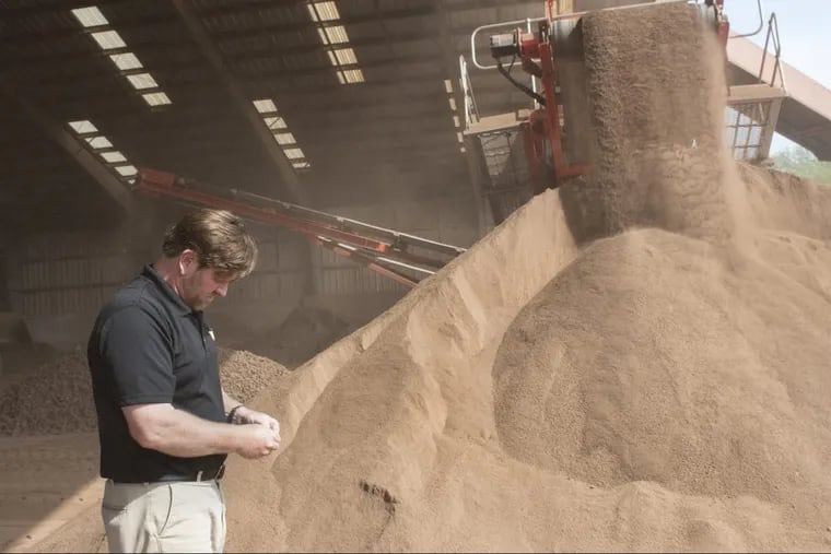 Grant McKnight, founder and president of Dura Edge, inspects ground clay at the production facility near Slippery Rock.