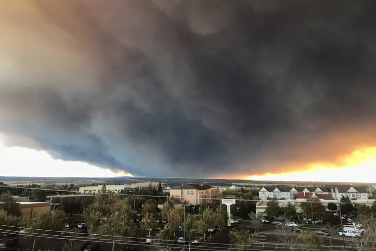 The massive plume from the Camp fire, burning in Feather River Canyon near Paradise, Calif., wafts over the Sacramento Valley as seen from Chico, Calif.  Climate scientists agree that climate change is a major factor in the increase of wildfires.