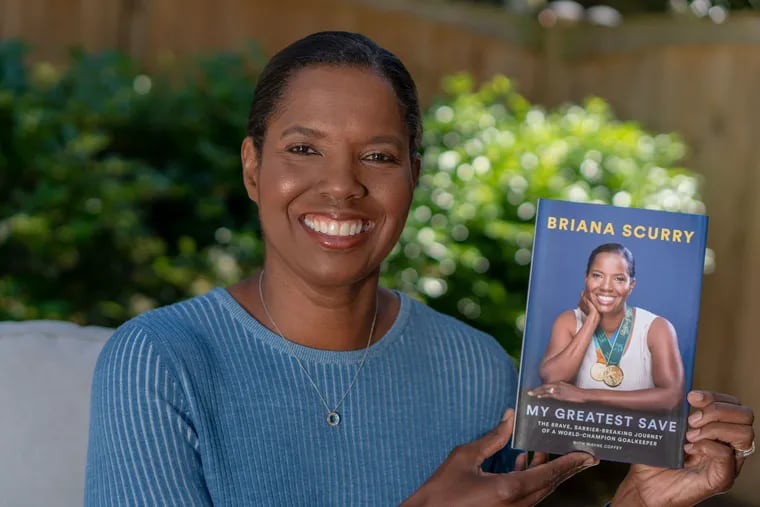 Former U.S. women's soccer team star goalkeeper Briana Scurry holds up a copy of her new book, "My Greatest Save: The Brave, Barrier-Breaking Journey of a World-Champion Goalkeeper."