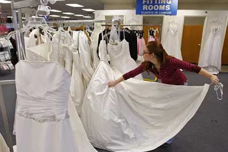 Mary Palmisano readies gowns for the big sale this Saturday at The Goodwill Store in Pennsauken. She says there will be about 100 dresses. Many are new, donated by bridal shops. (Michael S. Wirtz / Staff Photographer)
