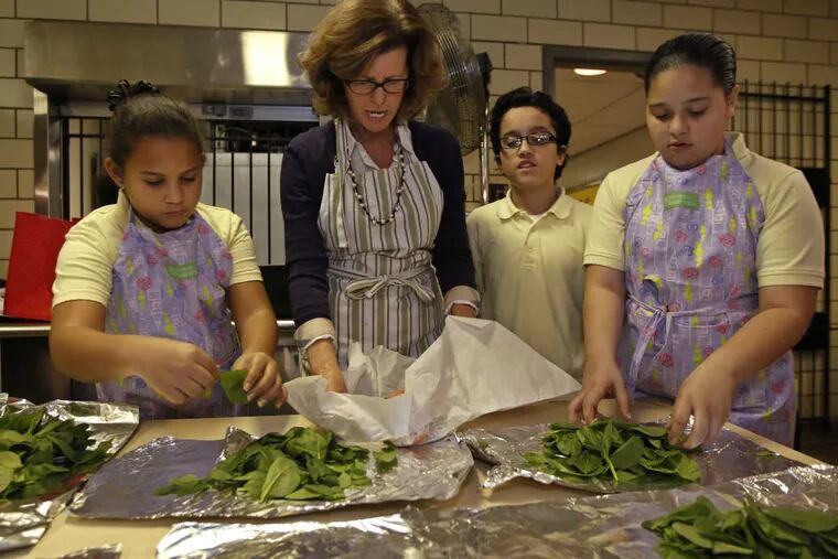 Left to right, Lixjohanne Alicea, 10, Maureen Fitzgerald, Mark Ramirez, 10, and Bianca Alicea, 10, get ready to place the salmon on top of the bed of spinach in the aluminum foil.