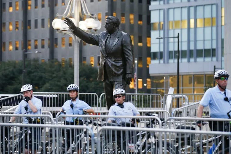 Philadelphia police officers stand guard in front of the Frank Rizzo statue at Thomas Paine Plaza during the Philly Is Charlottesville rally.
