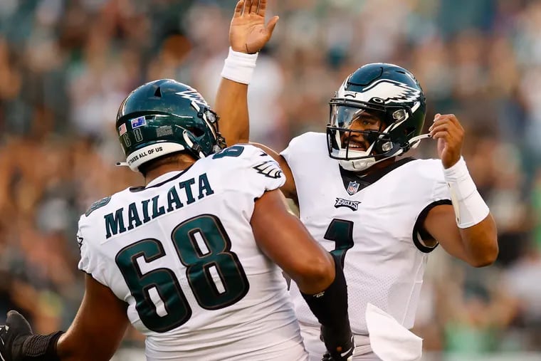 Eagles quarterback Jalen Hurts celebrates his first-quarter touchdown pass with offensive tackle Jordan Mailata against the New York Jets last Friday.