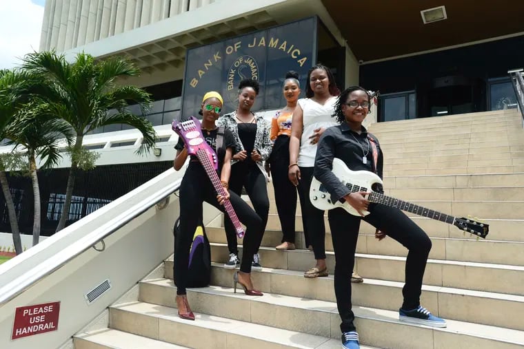In this June 13, 2019 photo, members of the all-female band ADAHEZ, Chevanese Palmer, from left, Karissa Palmer, Gabeana Campbell, Tashana Barnett and Shadeeka Daughma, pose for a photo on the steps of the Bank of Jamaica, in Kingston. Jamaica’s central bank thinks the country’s economy is doing very well and it is using an instantly recognizable symbol of the island to get this message to the people: reggae music. (AP Photo/Collin Reid)
