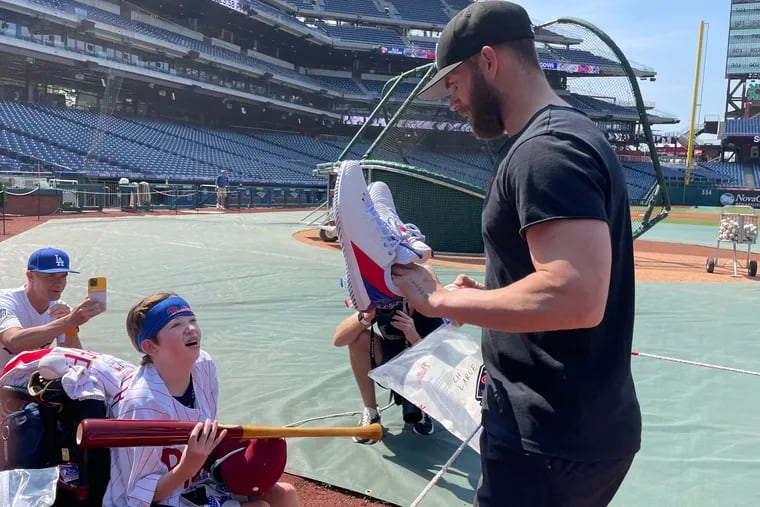 Bryce Harper hands 14-year-old fan Mason Strickland a pair of his cleats at Citizens Bank Park before a game. (Alex Coffey / Staff)