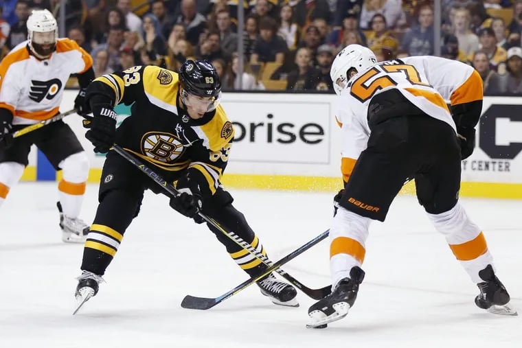 Brad Marchand (63), battling the Flyers’ Travis Sanheim in Thursday’s exhibition game, was outspoken about the stricter enforcement of faceoff and slashing violations in preseason games.