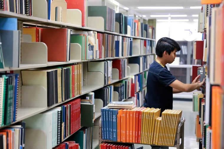 Marvin Vergara Jr. shelves books at Arizona State University’s library in Tempe. Students face voting hurdles including proof of residency, absentee ballot application, and voter identification.