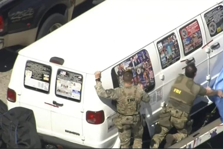 This frame grab from video provided by WPLG-TV shows FBI agents covering a van after the tarp fell off as it was transported from Plantation, Fla., on Friday, Oct. 26, 2018, that federal agents and police officers have been examining in connection with package bombs that were sent to high-profile critics of President Donald Trump. The van has several stickers on the windows, including American flags, decals with logos and text.