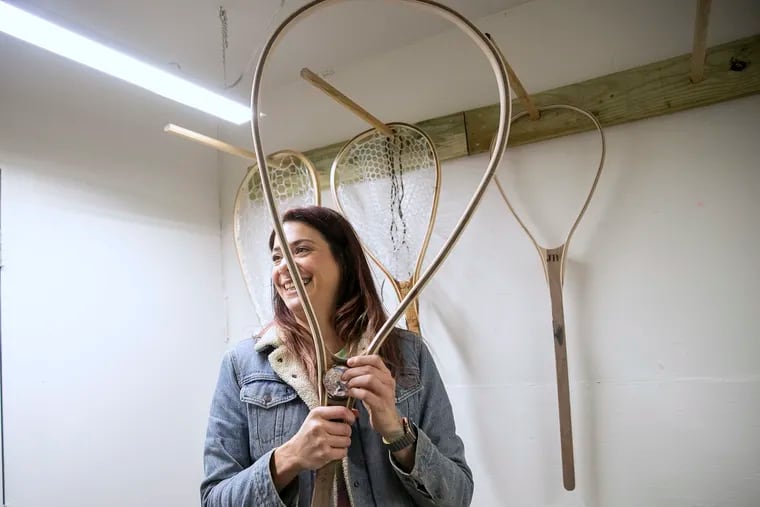 Tina Lewis holds up one of her fishing nets while in her studio in the Frankford section of Philadelphia on Friday, Feb. 18, 2022. Lewis left her corporate job during the pandemic to start making custom, wooden fishing nets.