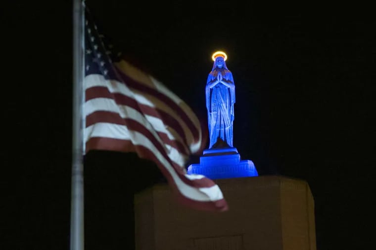 The Virgin Mary statue atop Our Lady of Lourdes Medical Center in Camden is lighted blue Thursday in honor of the Chicago Cubs' World Series victory. The hospital has a $100 million plan to transform the campus and lop the top off its landmark building, moving the iconic statue to ground level.