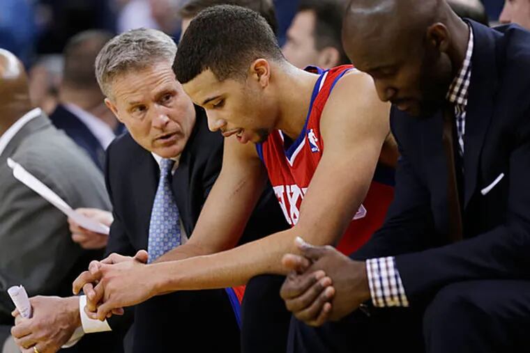 Brett Brown, left, talks to Philadelphia 76ers point guard Michael Carter-Williams during an NBA basketball game against the Golden State Warriors on Monday, Feb. 10, 2014, in Oakland, Calif. (Marcio Jose Sanchez/AP)