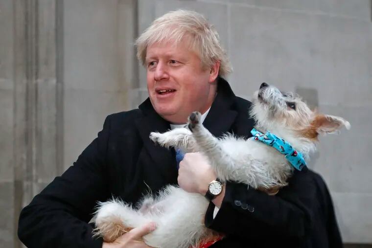 Britain's Prime Minister and Conservative Party leader Boris Johnson holds his dog Dilyn as he leaves after voting in the general election at Methodist Central Hall, Westminster, London, Thursday, Dec. 12, 2019.