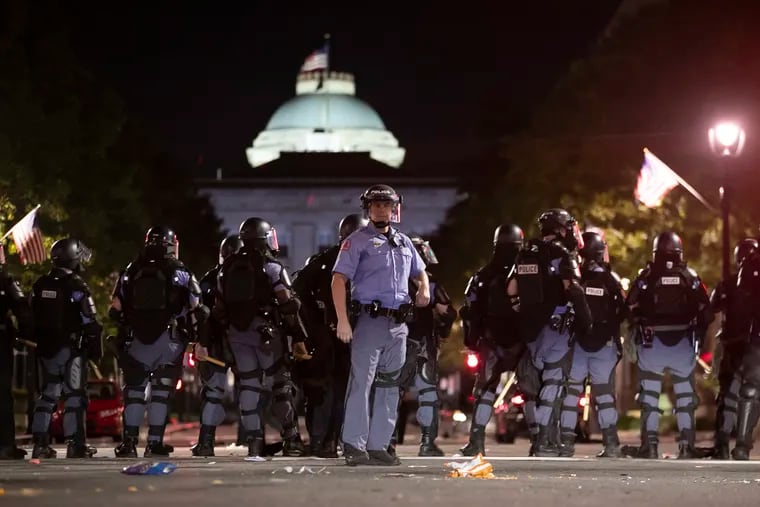 Raleigh Police block Fayetteville Street at Hargett Street as they work to return order after a night of violent demonstrations early Sunday, May 31, 2020, in Raleigh, N.C., as people nationwide protested the Memorial Day death of George Floyd, who died in police custody in Minneapolis.