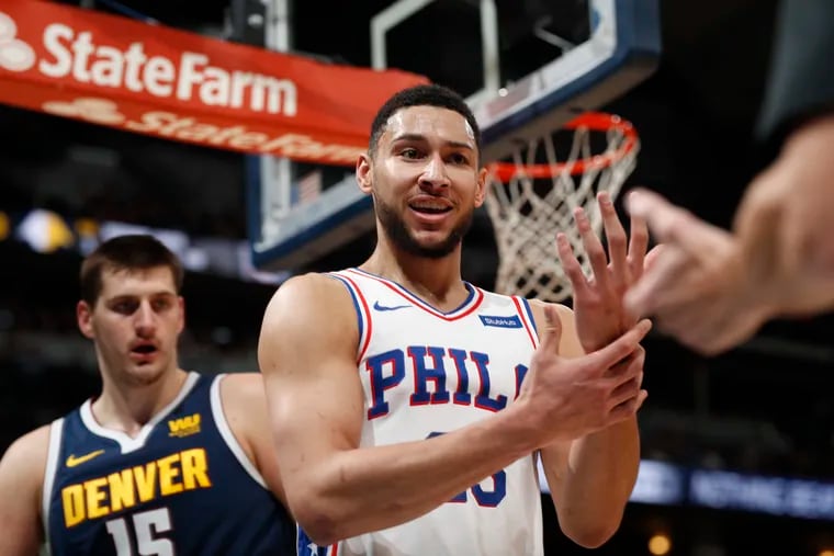 Philadelphia 76ers guard Ben Simmons, front, argues for a call after driving to the rim for a shot past Denver Nuggets center Nikola Jokic during the first half of an NBA basketball game Saturday, Jan. 26, 2019, in Denver. (AP Photo/David Zalubowski)