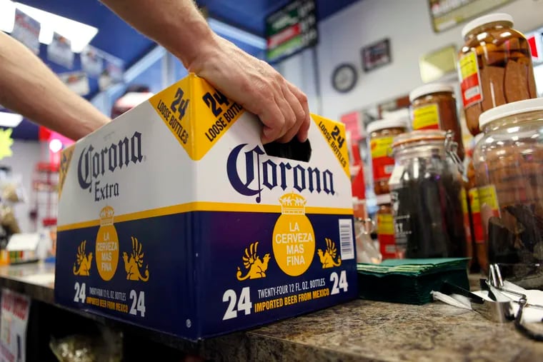 FILE – In this April 1, 2010, file photo, a customer places a case of Corona Extra on the checkout counter for purchase at Susquehanna Beer and Soda in Marysville, Pa. Constellation Brands, the parent company of Corona beer and other alcoholic drinks, expanded its stake in h Canopy, a Canadian pot producer.