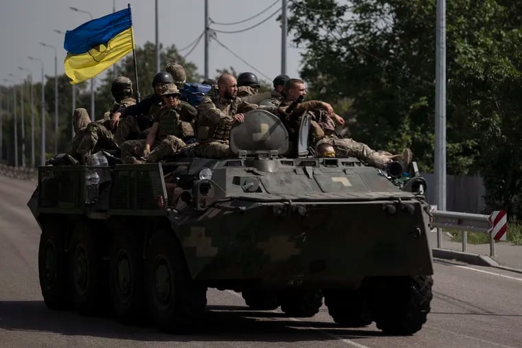 Ukrainian servicemen ride atop an armored vehicle on a road in the Donetsk region of eastern Ukraine on Aug. 28. A growing flow of Western weapons that were delivered over the summer is now playing a key role in the military's counteroffensive, helping Ukraine significantly boost its precision strike capability.