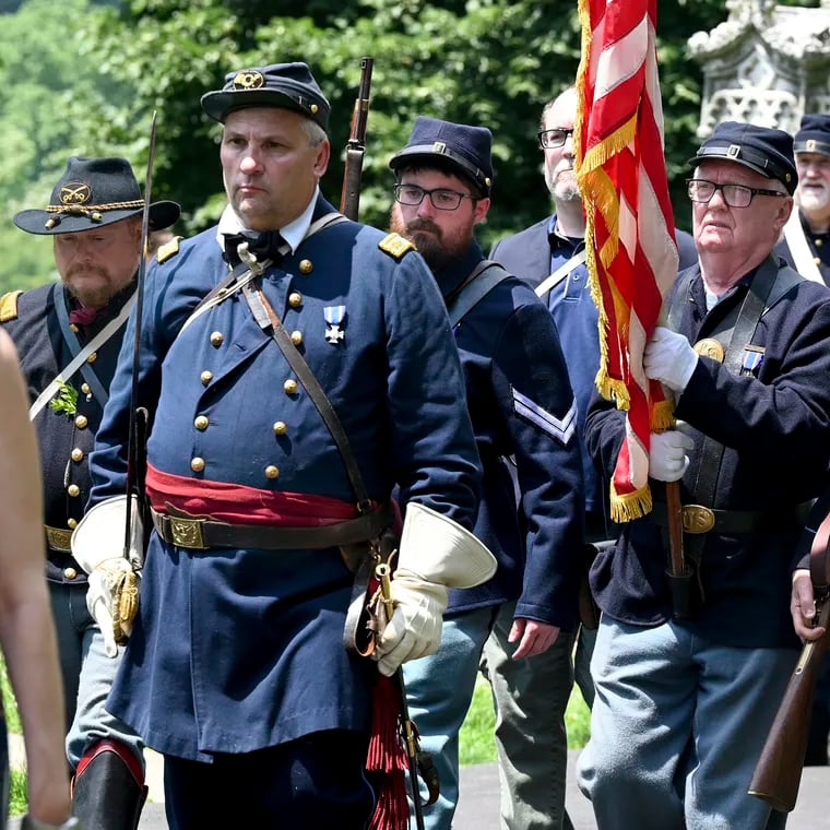 A color guard made up of members of various local Civil War reenactment units marches between ceremonies at the cemetery.