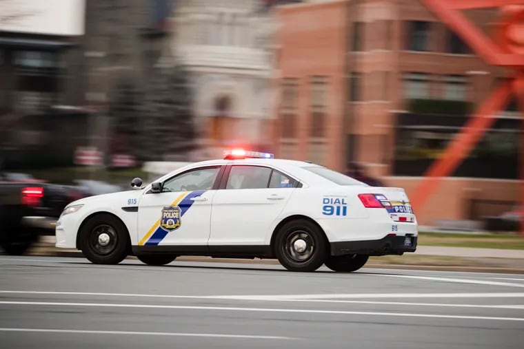 A police car drives with its lights flashing in Philadelphia.
