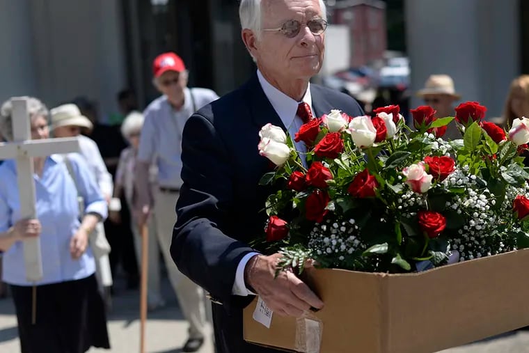David Walsh, 70, walks with a box of roses to the unmarked grave of the 47 fetuses found in Kermit Gosnell's West Philadelphia abortion clinic, during a memorial service on June 10, 2015, at Laurel Hill Cemetery in Philadelphia, Pa. ( BEN MIKESELL / Staff Photographer )